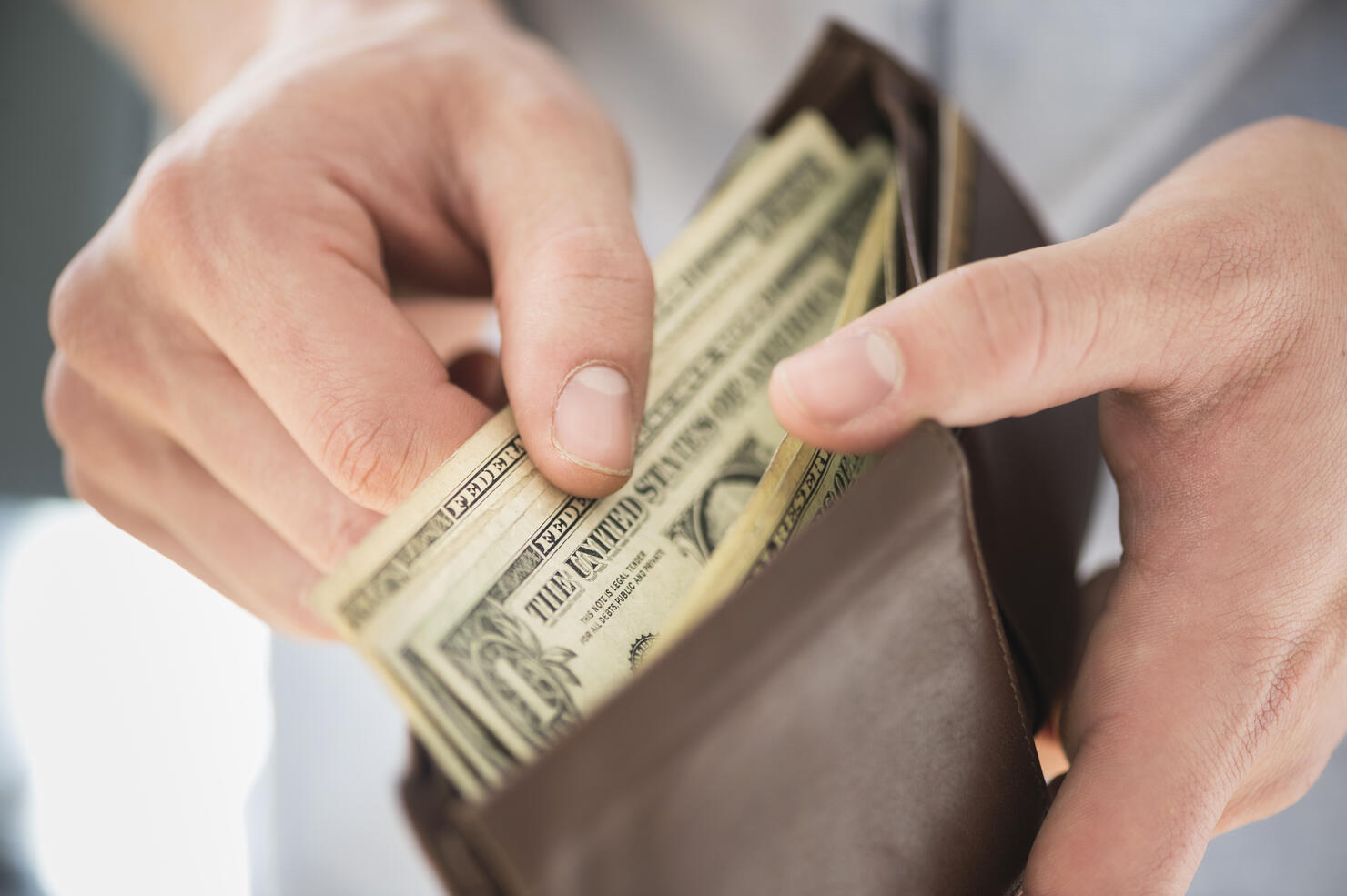 Young man holding wallet and counting money, Jersey City, New Jersey, USA