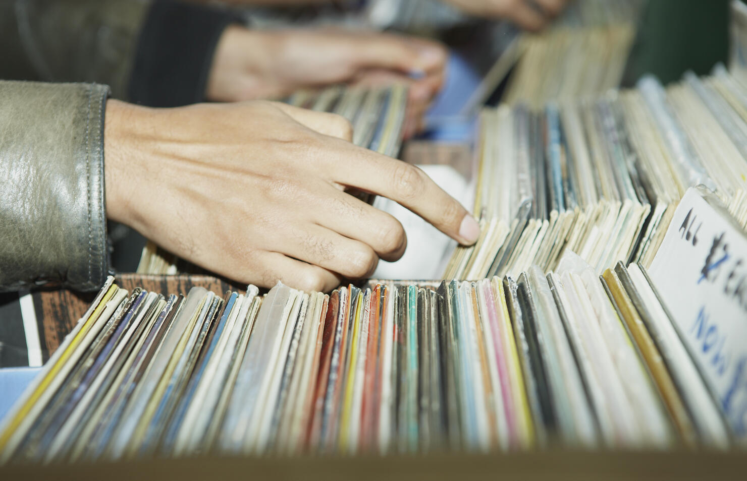 CU on hands searching through vintage records 