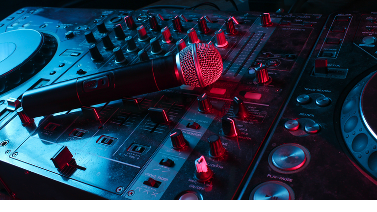 Night club, nightlife concept. Disco. Microphone on DJ remote. Neon red blue light