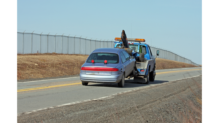 Tow Truck Towing A Vehicle On A Two Lane Highway