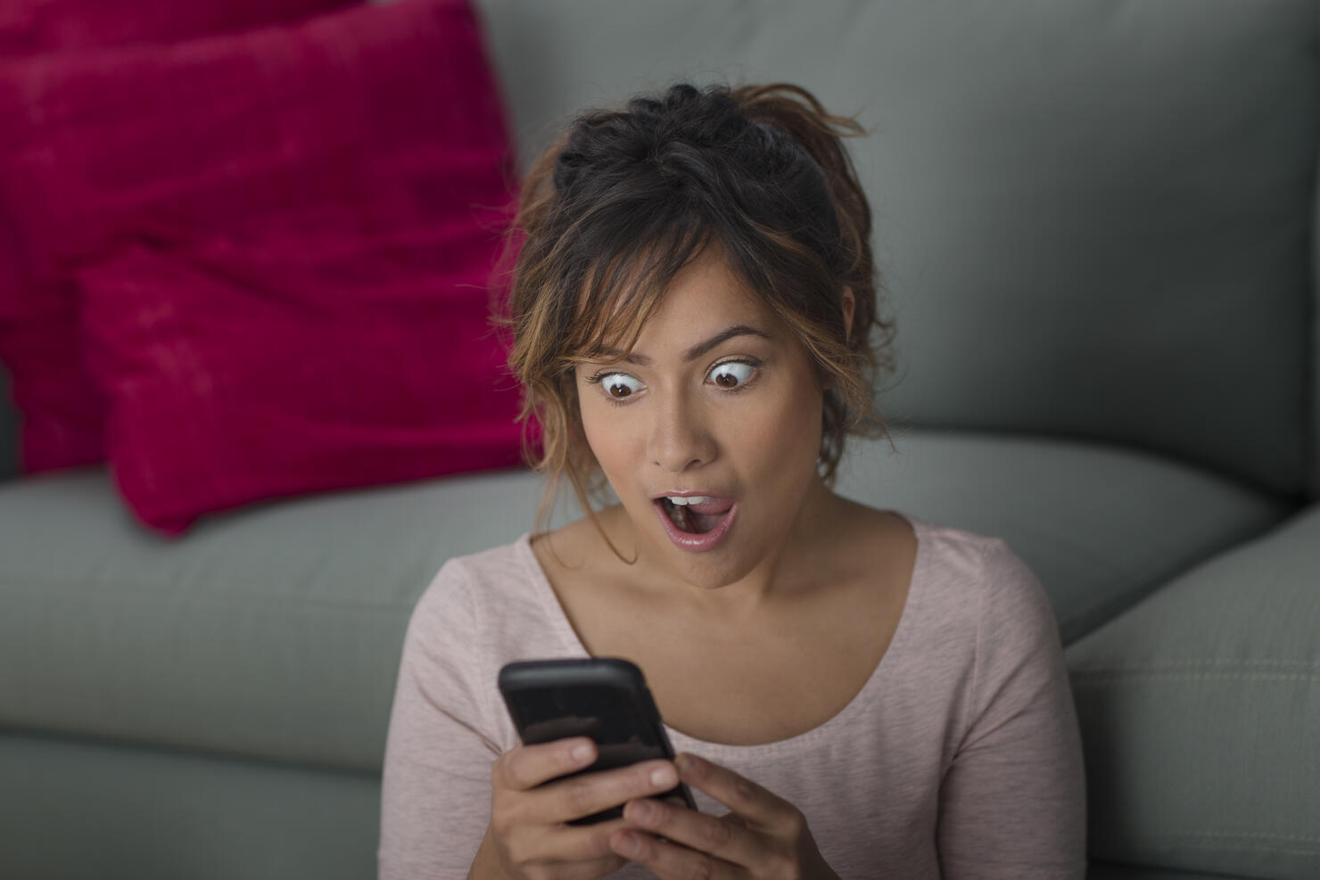 Woman surprised at message on smartphone