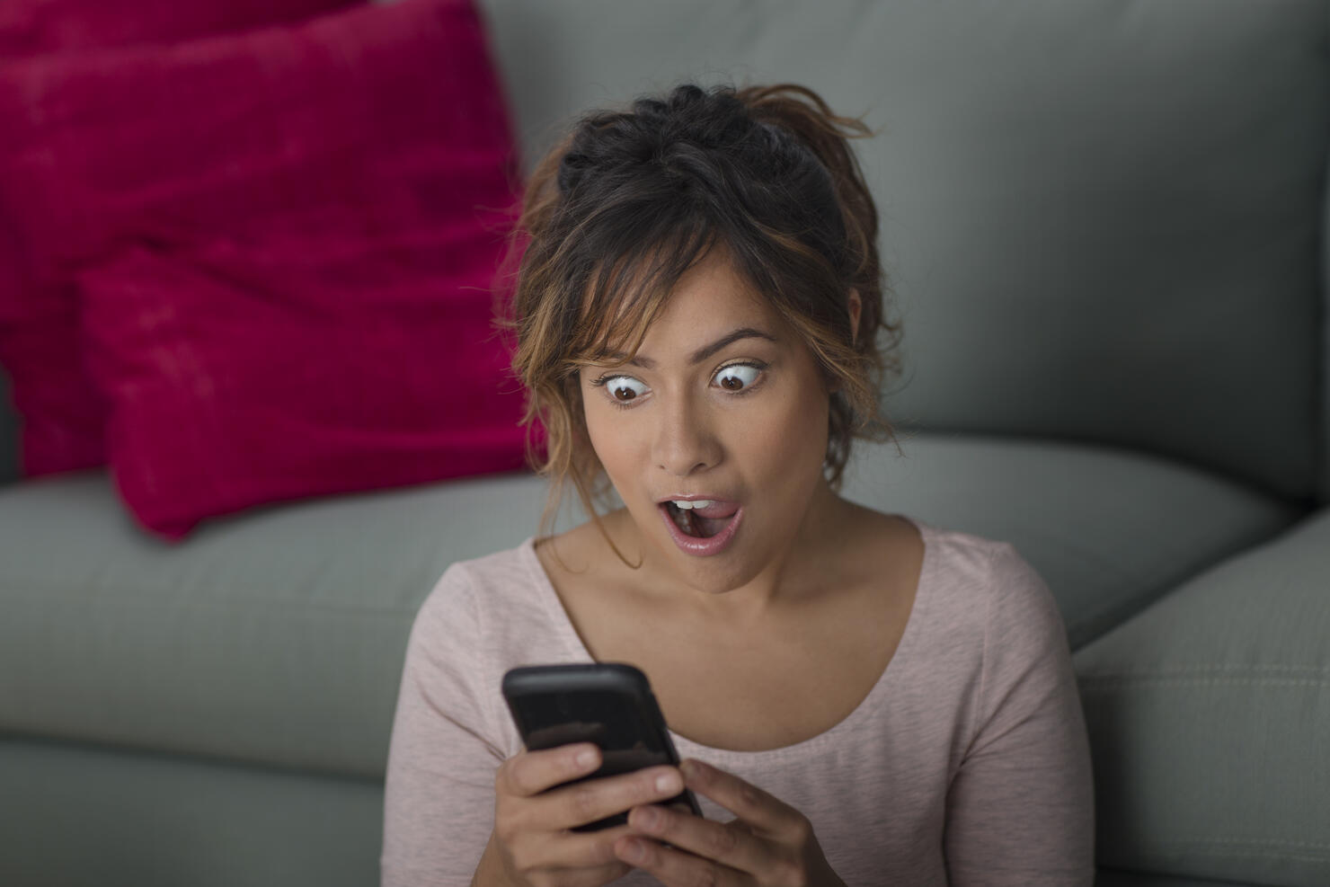 Woman surprised at message on smartphone