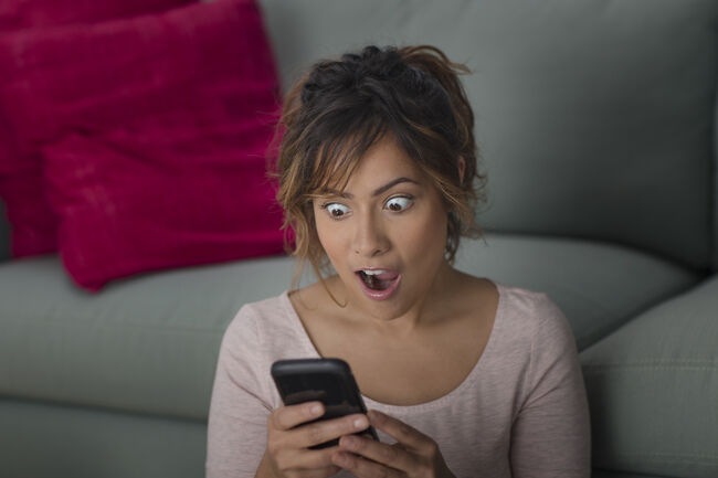 Woman surprised at message on smartphone