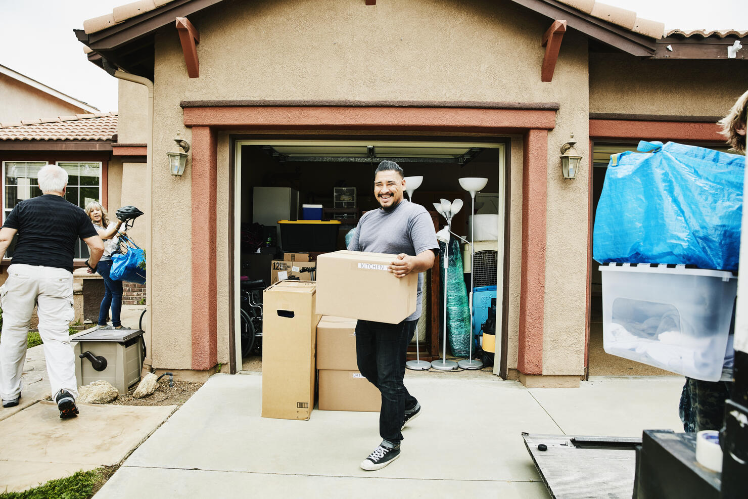 Laughing man carrying box into new home on moving day