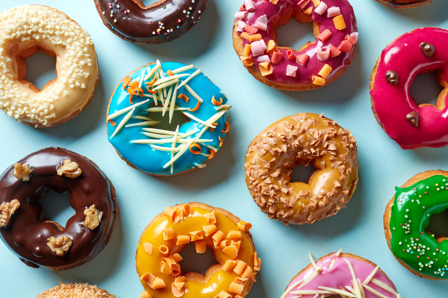 Various donuts on blue background, from above