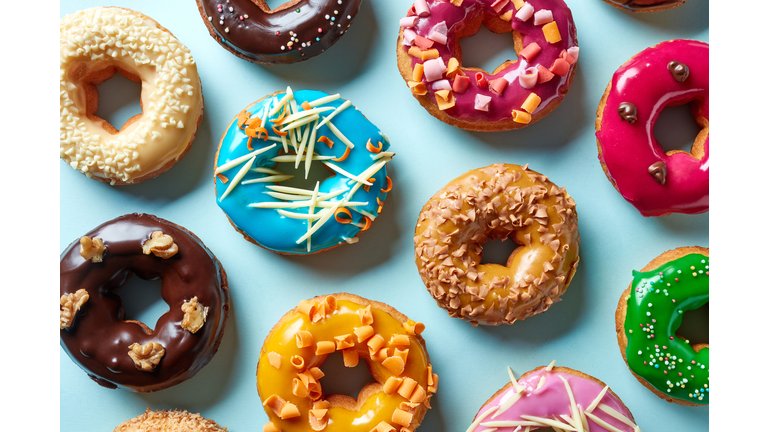 Various donuts on blue background, from above