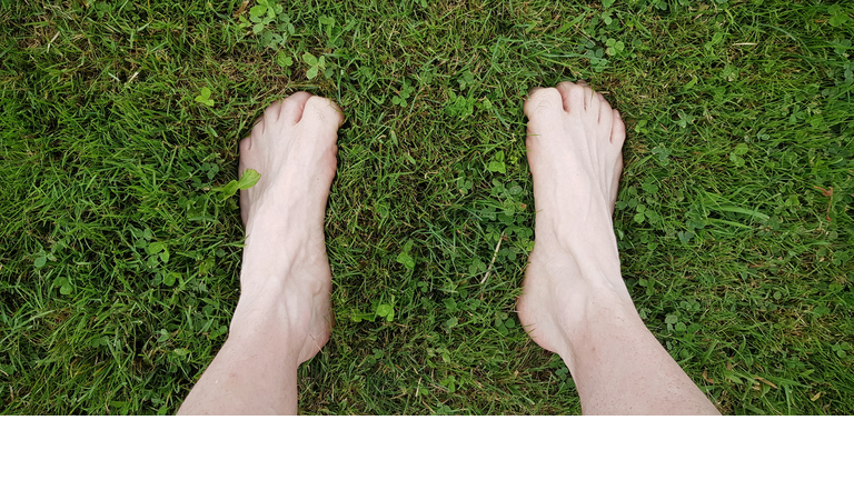 Feet barefoot over a grass background