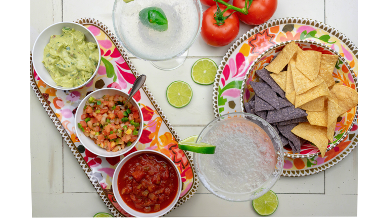 Mexican food flat lay - top view of chips, salsas, fresh ingredients  and margaritas