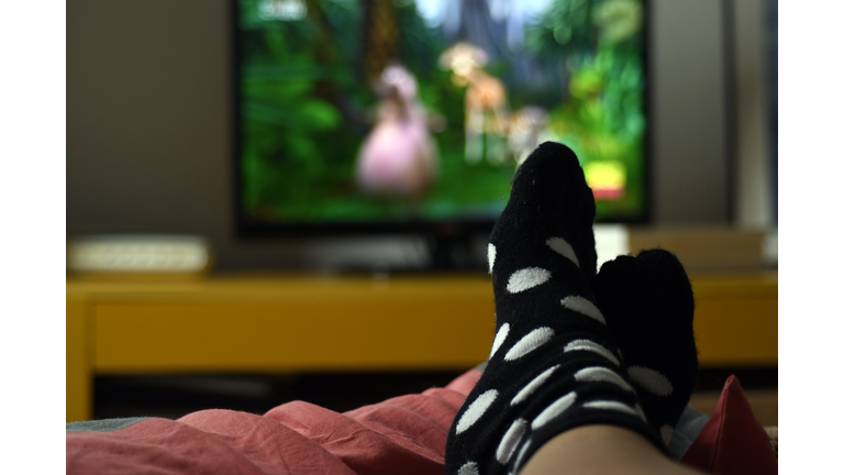 Feet of person with socks watching TV
