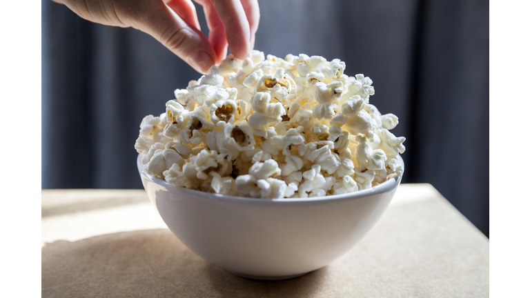 Hand Picking Freshly Made Popcorn From The Bowl