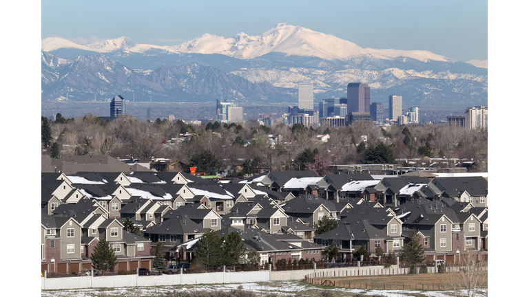 Wintery homes downtown Denver Colorado skyscrapers with Rocky Mountains