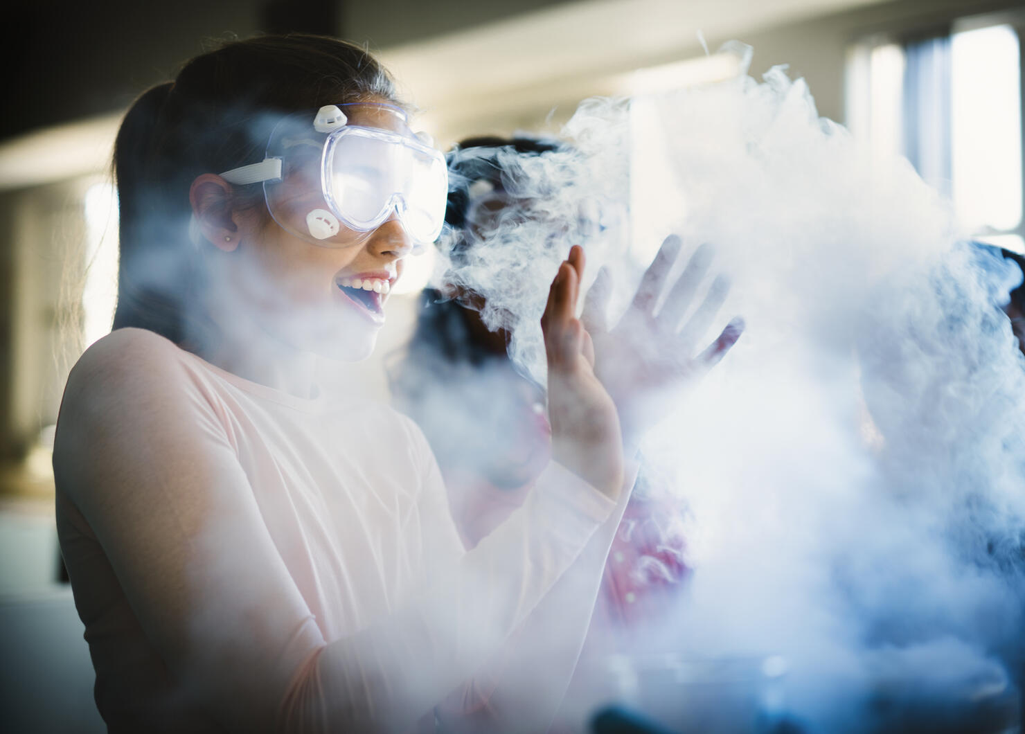 Smiling girl gesturing while surrounded by smoke
