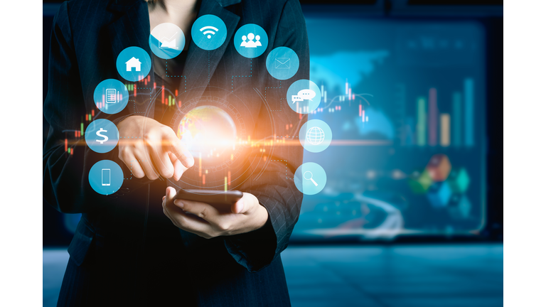 Businesswomen using mobile phone analyzing data and economic growth graph chart. Technology digital marketing and network connection.