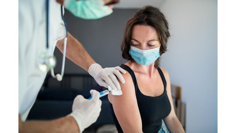 Woman with face mask getting vaccinated, coronavirus concept.