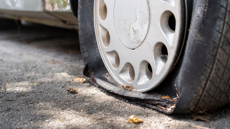 Flat tire of an old rusty car close up