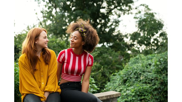Two women sat on wall