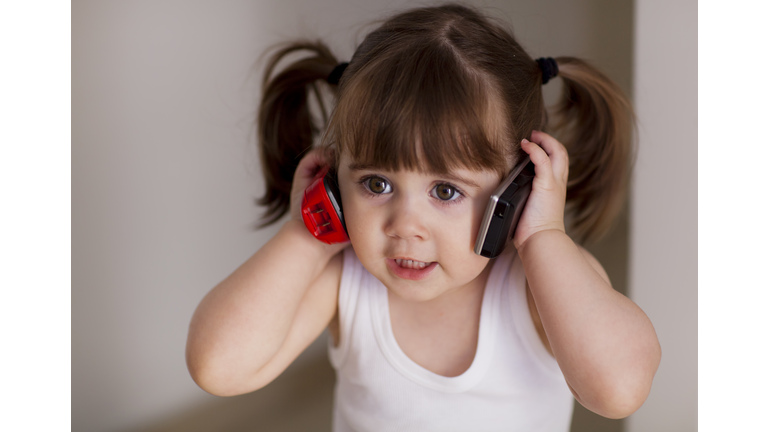 Portrait of a small girl talking on phone