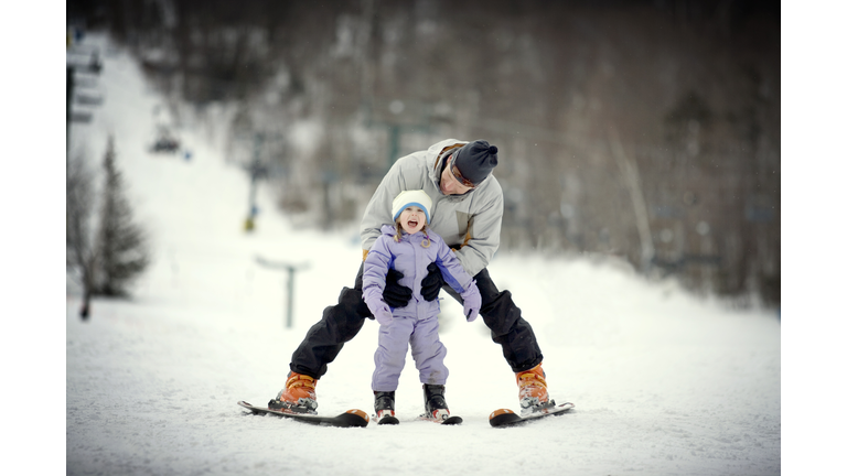 Father skiing with daughter