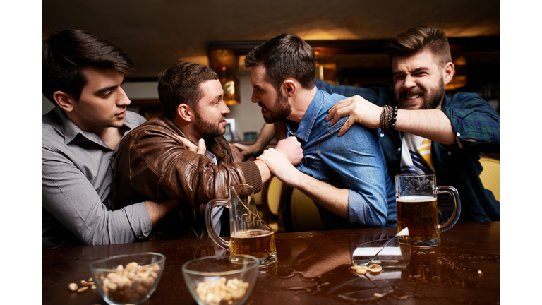 Aggressive men having fight in pub