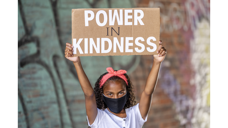 Beautiful African American girl holding a protest sign