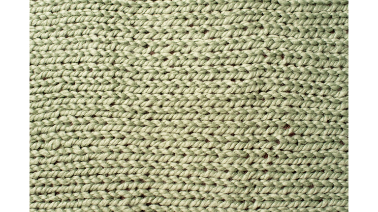 Texture of green wool big knit blanket. Large knitting. Plaid merino. Top view