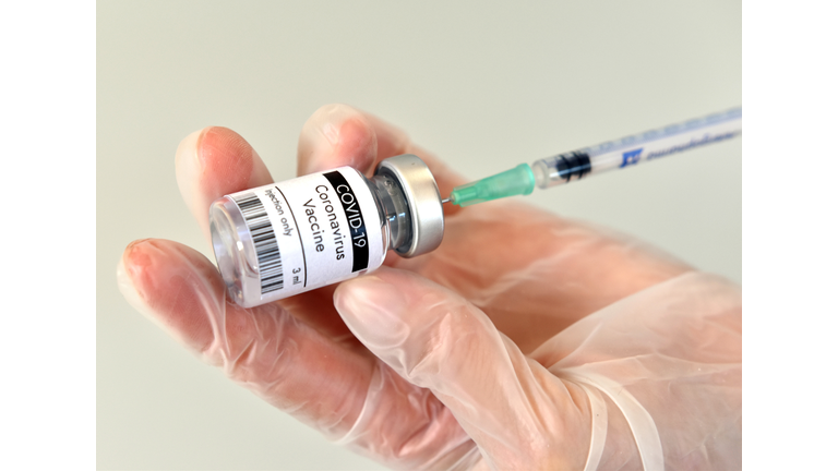 Coronavirus vaccine. Doctor wearing gloves handles syringe and vial with COVID-19 vaccine testing and prepares for injection. COVID-19 immunization. Healthcare and medical concept.