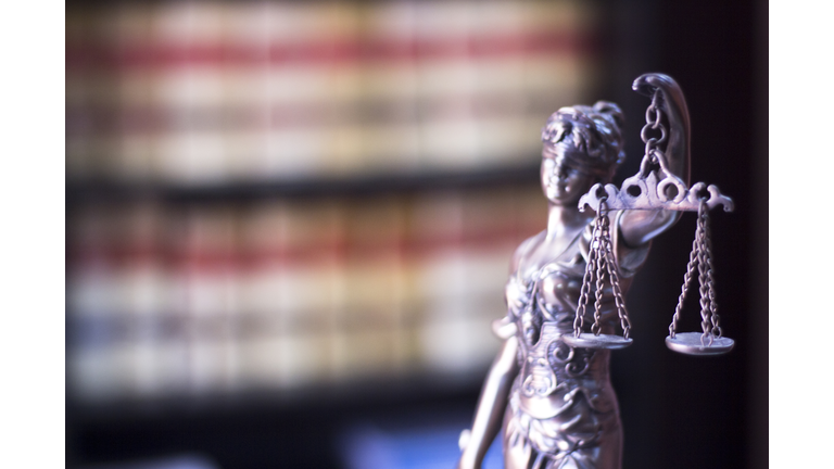 Close-Up Of Lady Justice Figurine In Courtroom