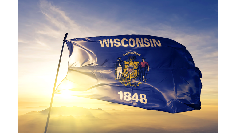 Wisconsin state of United States flag textile cloth fabric waving on the top sunrise mist fog