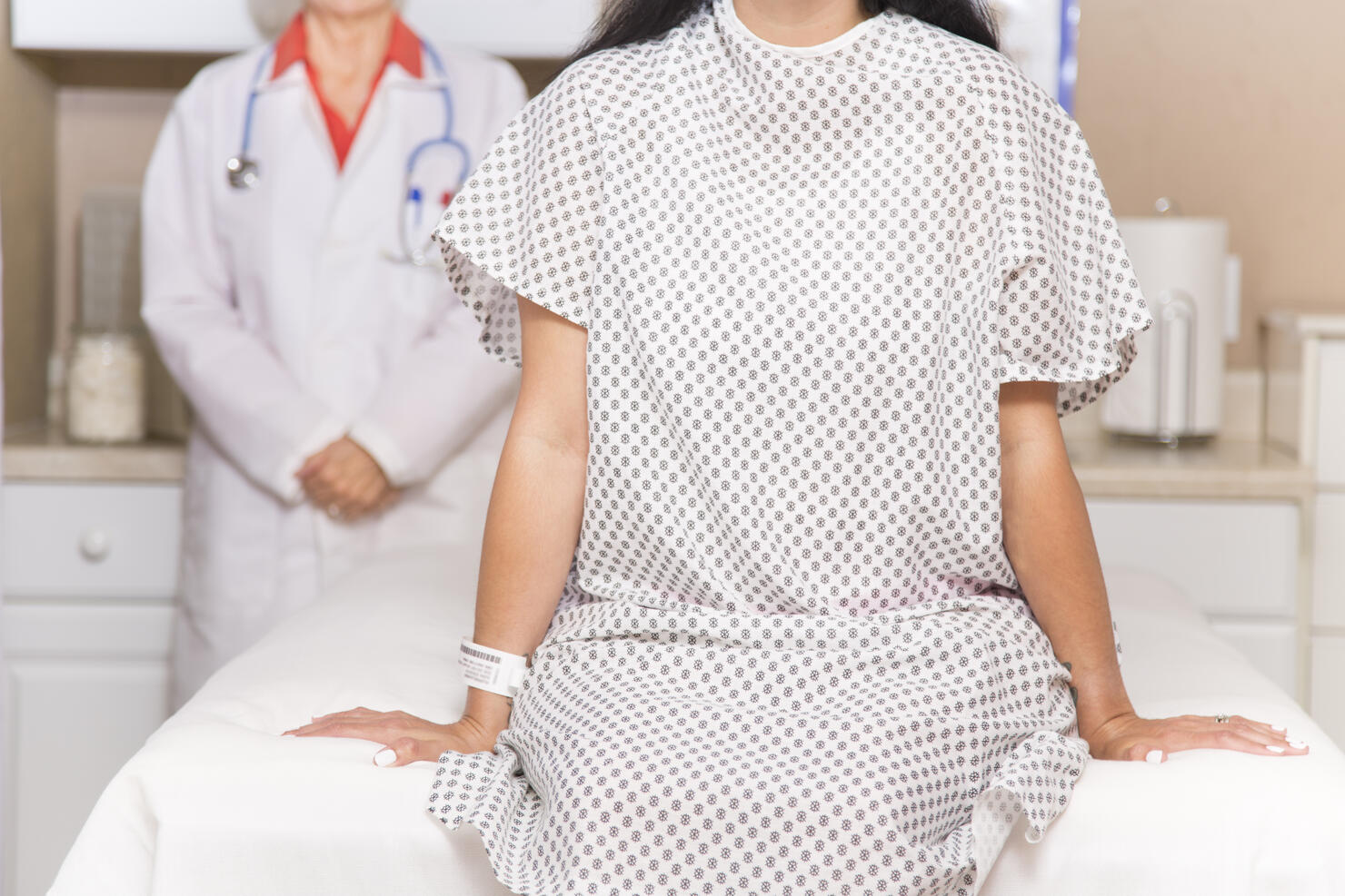 Woman prepares for breast exam, mammogram at doctor's office or hospital.