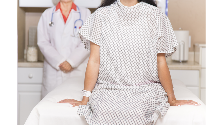 Woman prepares for breast exam, mammogram at doctor's office or hospital.