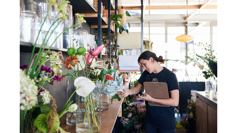 Florist standing in her flower shop talking on the phone