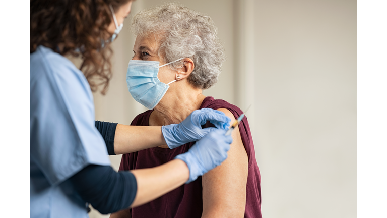 Doctor giving Covid vaccine to senior woman