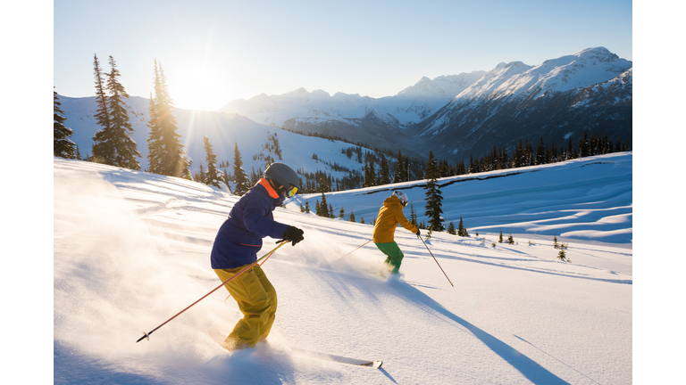 Couple skiing on a sunny powder day