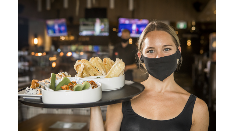 Waitress carrying a tray with food.