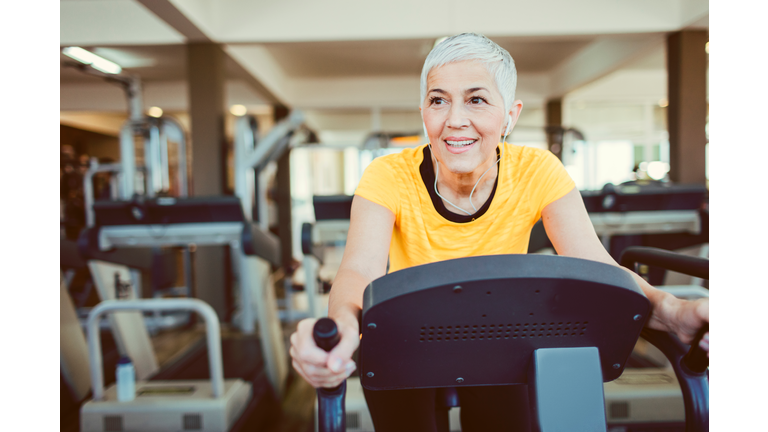 Mature Woman Exercising In Gym.