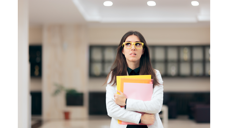 Confused Businesswoman Holding Paperwork in Office Building