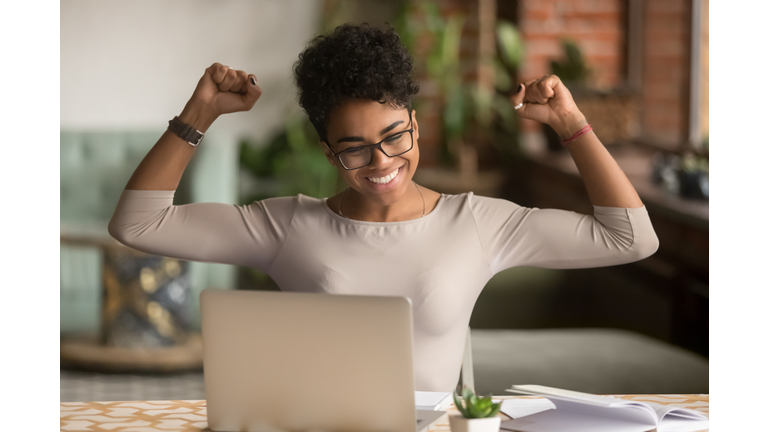 Excited african woman feeling winner rejoicing online win on laptop