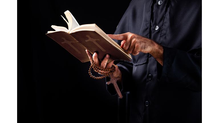 Pastor reads the Bible.The cross in the Pastor hand