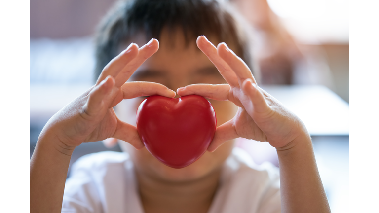 The child holding a red heart