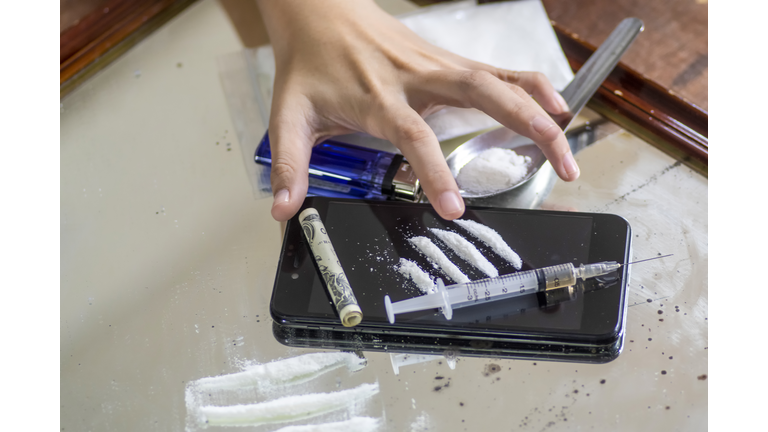 Young man hand touch a syringe and drug overdose,The concept of crime and drug addiction.