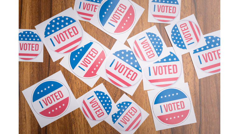 Multiple I Voted stickers on table - concept of voter fraud showing many I voted stickers.