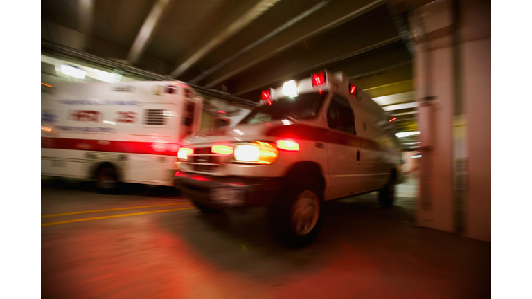 Ambulance pulling away from hospital (blurred motion)