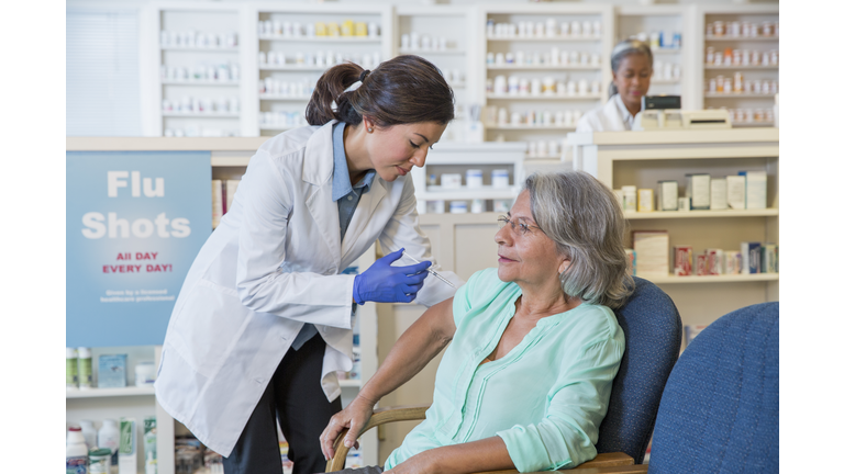 Pharmacist giving customer flu shot