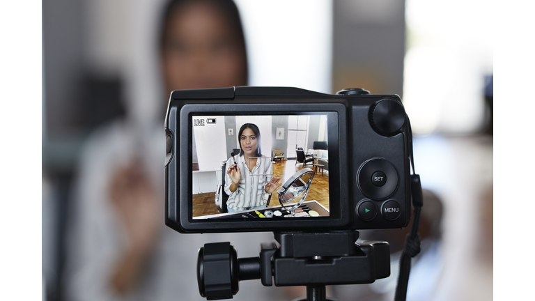 Female influencer recording make-up tip videos for her blog