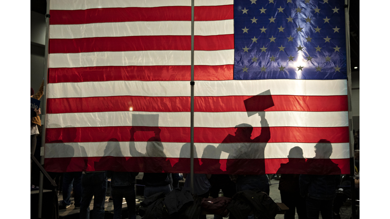 People Silhouetted Against An American Flag