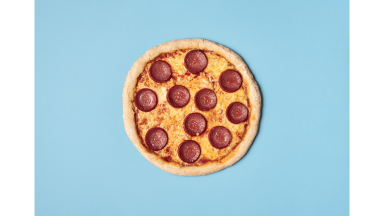 Tasty Pizza Salami With Melted Cheese, Mozzarella And Tomato Sauce On A Blue Background.