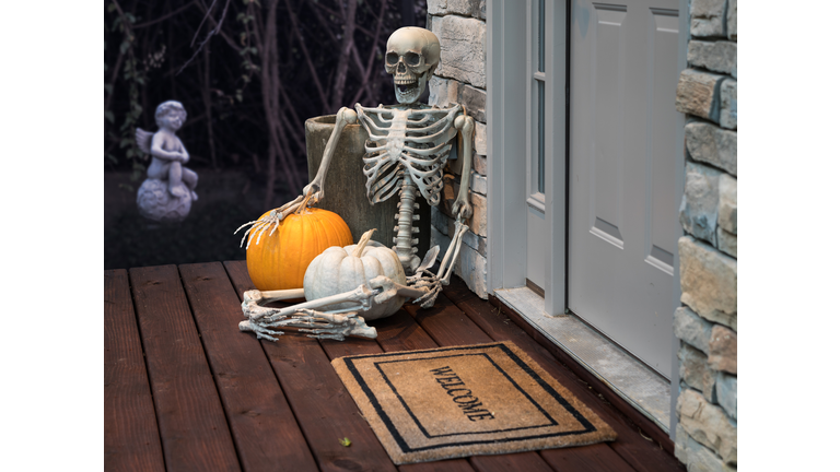 Skeleton and pumpkins in doorway for Halloween