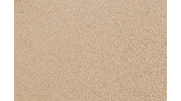 Close-up of smooth sand at a beach texture background.