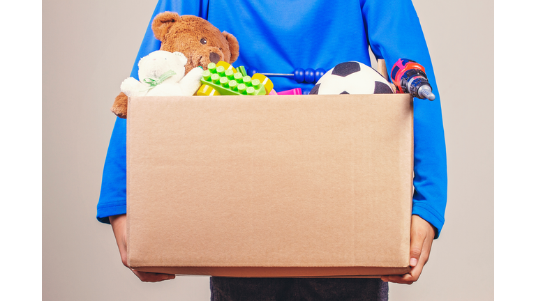 Midsection Of Woman Holding Box Full Of Toys For Donation