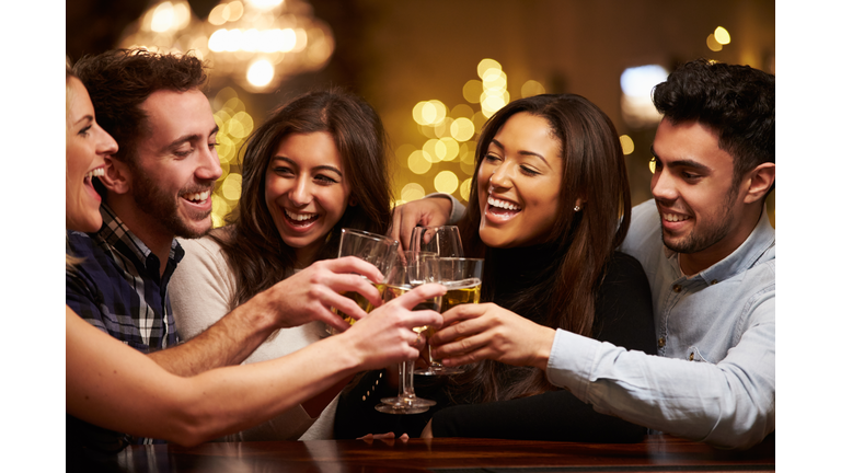 Group Of Friends Enjoying Evening Drinks In Bar